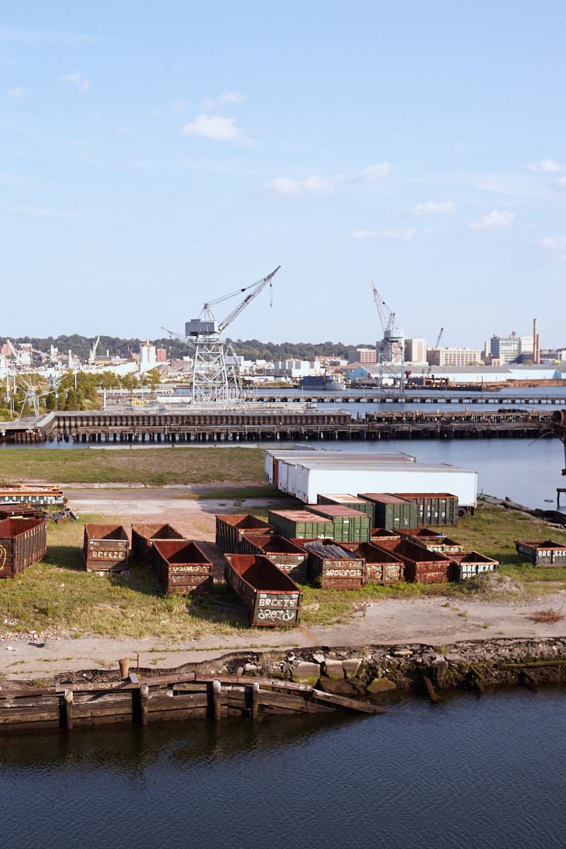 Landscape of industrial waterfront area near Ikea with open, rusting shipping containers and drains in Red Hook, Brooklyn, NYC