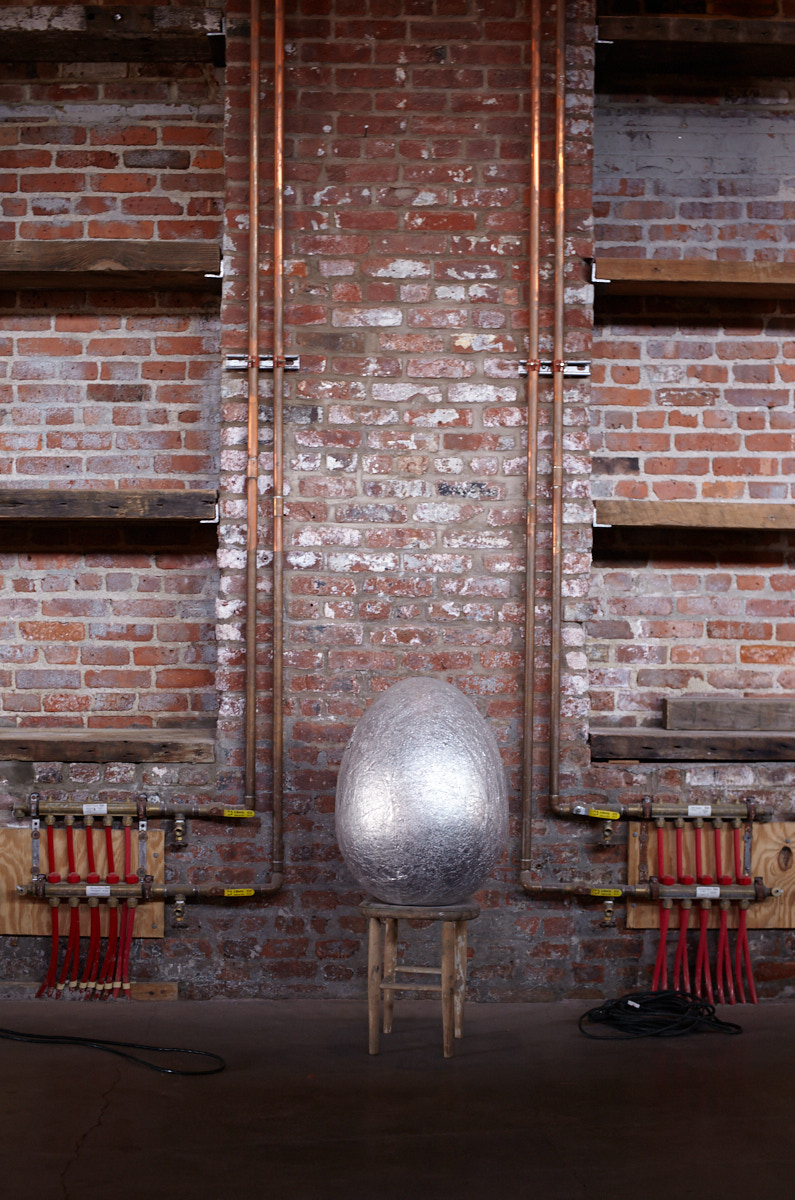 Pioneer Works, interior view of a large shiny silver-coated egg art piece in Red Hook, Brooklyn, NYC