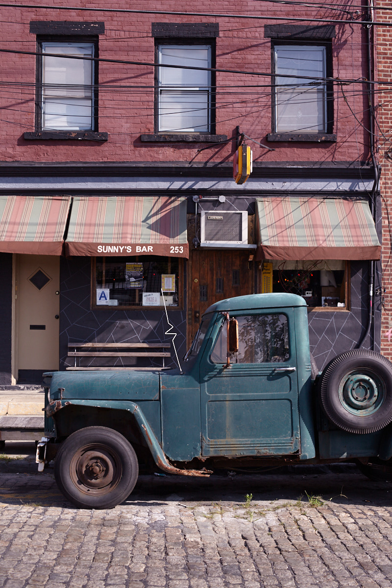 Vintage 1948 Jeep Willys-Overland pick-up truck outside Sunny's Bar parked on a cobble stone street in Red Hook, Brooklyn, New York.