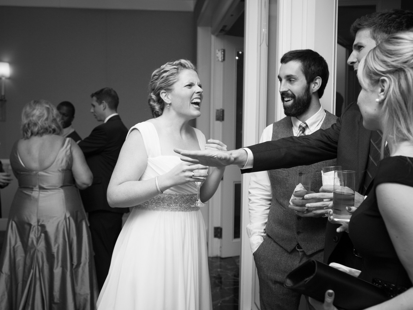 Stylish modern wedding ceremony held at posh, high-end, luxurious Four Seasons Hotel in downtown Philadelphia. People celebrate with drink and talk after wedding ceremony.