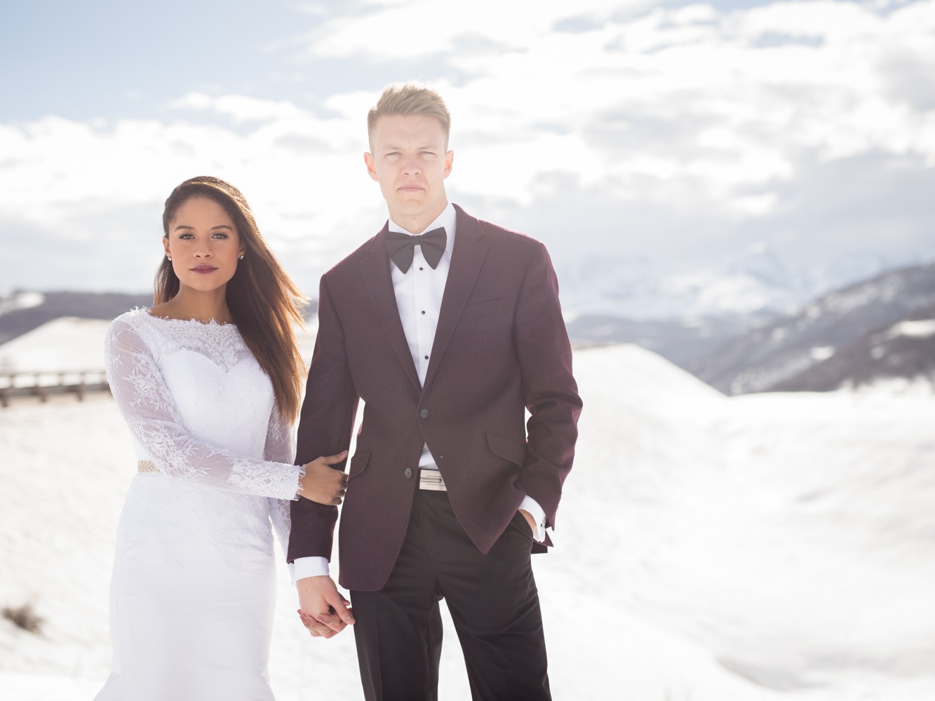 Portrait of interracial bride and groom in the snowy mountains outside Ogden, Utah