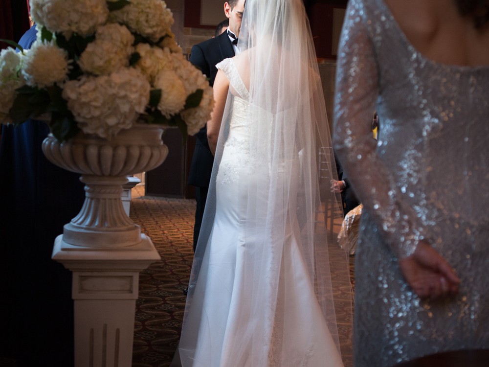 A Muslim couple have an opulent wedding ceremony at the Society Room with large family and many friends at beautiful hotel in Hartford, Connecticut. Bride and groom look at each other as wedding officiant performs ceremony at the Society Room.