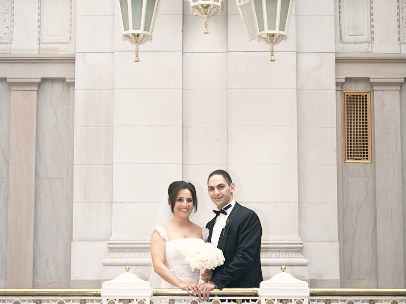 A Muslim couple have an opulent wedding ceremony at the Society Room with large family and many friends at beautiful hotel in Hartford, Connecticut. Bride and groom pose for pictures.