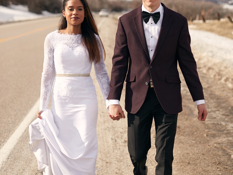 Portrait of interracial bride and groom in the snowy mountains outside Ogden, Utah