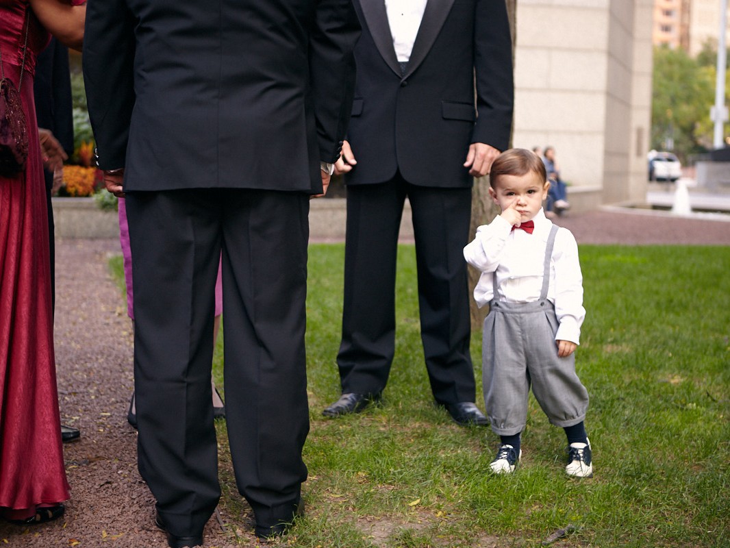 Stylish modern wedding ceremony held at posh, high-end, luxurious Four Seasons Hotel in downtown Philadelphia. Cute little boy stands by group of adults talking before wedding ceremony.
