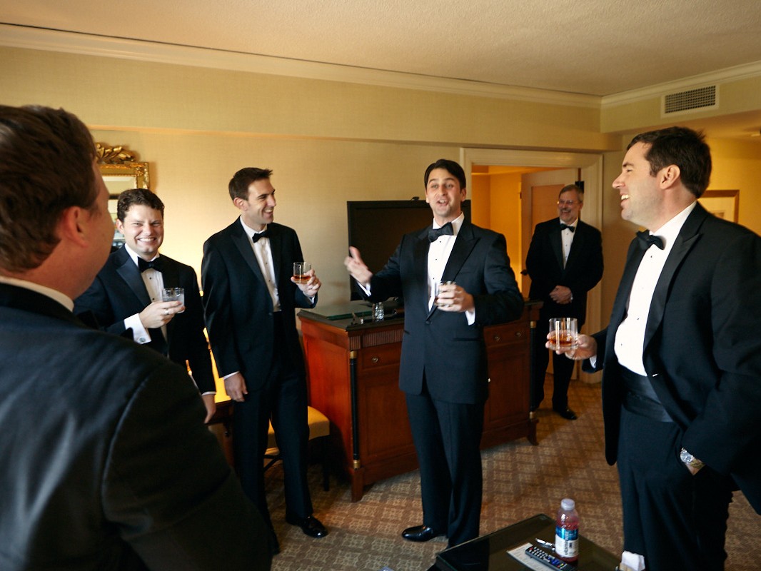 Stylish modern wedding ceremony held at posh, high-end, luxurious Four Seasons Hotel in downtown Philadelphia. Groom laughs loudly during speeches at wedding.